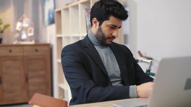 Close up view of attractive young man carefully rereading, proofreading, editing the documents. Working hard, responsibility, workaholic. Slow motion, male portrait
