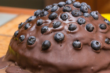Chocolate cake made of chocolate pancakes with glaze, with blueberries. Vintage style.