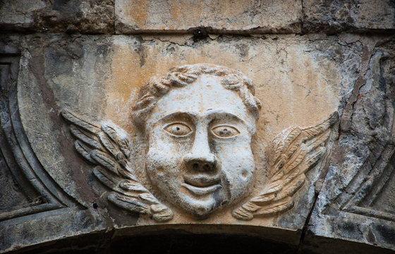 Smiling face of angel on the front of Cathedral of Notre Dame of Assumption in Entraveaux (Alpes de Haute Provence, France)