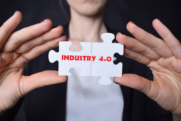 Businessman holding a puzzle with the inscription:INDUSTRY 4.0