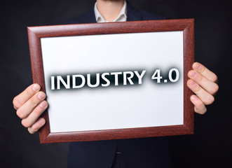 In the hands of a businessman a frame with the inscription:INDUSTRY 4.0