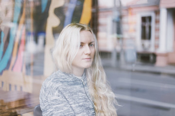 Fototapeta premium Young fashion woman sitting at the table in cafe. Stylish female model with blonde hairs