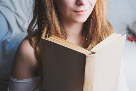 Woman with ginger dreadlocks is reading a book