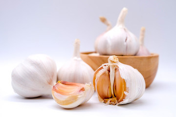 Close up: Group of garlic in vintage bowl isolated on white background