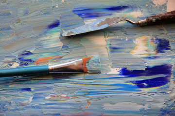 Closeup background of palette with brush and palette knife