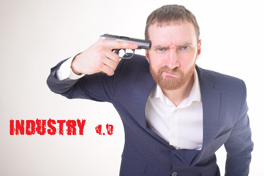 The businessman holds a gun in his hand and shows the inscription:INDUSTRY 4.0