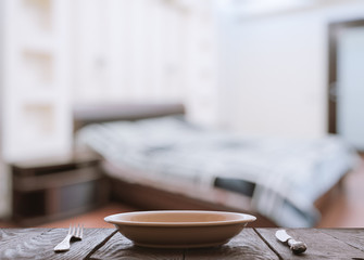 empty plate with fork and knife on wooden table