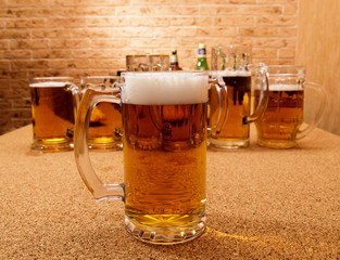 Glasses of beer and plates of appetizers are on the table.