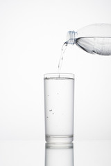 The water is nearly filled with a glass of water separated from the white background.