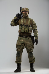 Photo of soldier in camouflage with gun in studio