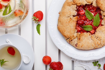 Strawberry galette and herb tea. Homemade healthy wholegrain berry open pie. Fruit tart. Top view.