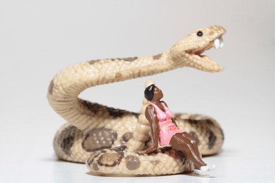 miniatura di donna seduta su un serpente a sonagli
