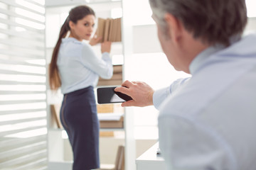 Obraz premium Digital camera. Selective focus of a modern smartphone being used for taking inappropriate photos in the office