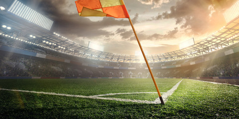 Sport. Empty football soccer field with white marks, green grass texture and orange corner flag.