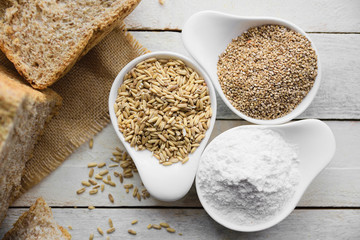 Wholemeal bread on a burlap fabric next to some flour and cereals, from above. Empty copy space for Editor's text.