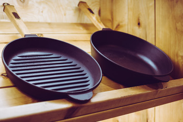two heavy cast iron pans at the wooden display in the chop of craft crockery
