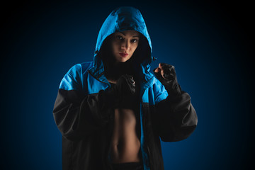 girl boxer in a sweatshirt with a hood on a blue background