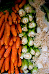 stacks of carrots, leek and chard on market stall in cadiz, spain