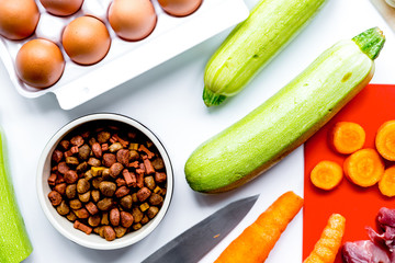 healthy dogfood with eggs, vegetables and meat on kitchen backgr