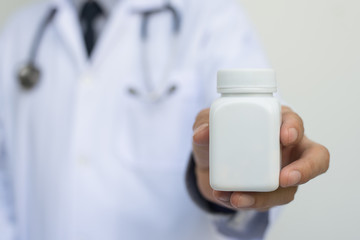 Doctor holding bottle of pills
