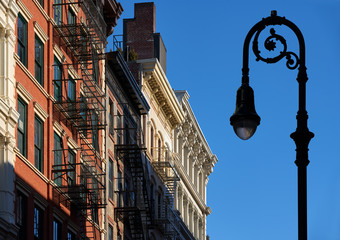 Soho building facades with cornices, fire escapes and a lamp-post. Manhattan, Soho, New York City