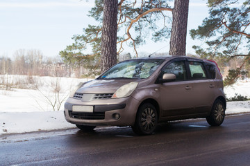 in a beautiful sunny day beige car parked at the side of the highway