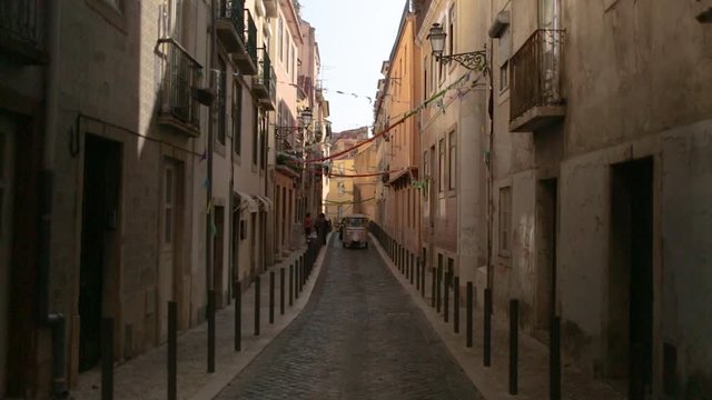 A vespa driving through an alley in Lisbon