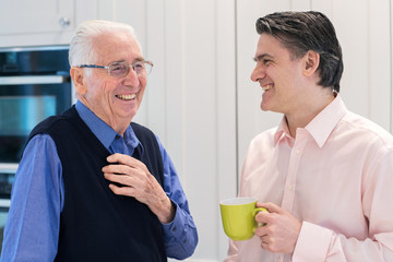 Man Taking Time To Visit Senior Male Neighbor And Talk
