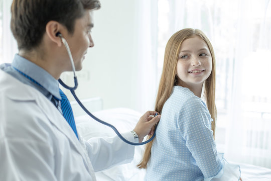 Doctor listen to girl back in a hospita. People with health care and medical concept