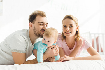 Obraz premium Portrait of happy family with infant daughter with baby dummy