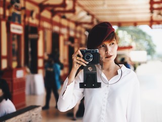 Young traveler woman holding vintage camera.