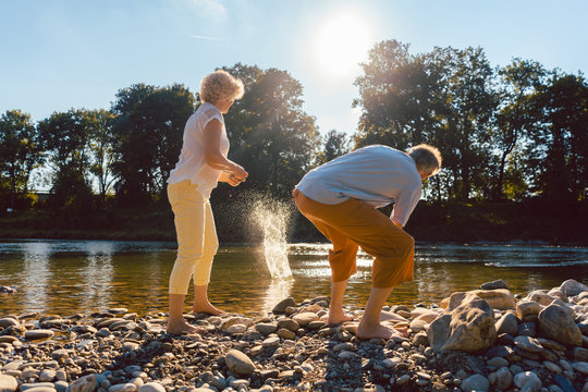 Senioren beim Steine flitschen auf dem Fluss