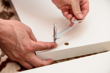 Close up on hands with wrench assembling furniture