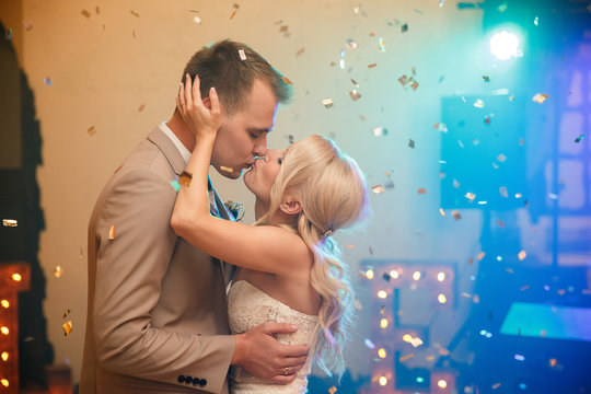 First wedding dance of bride and groom. Newlywed couple dancing in dance hall at wedding party. Just married couple kissing with special effects