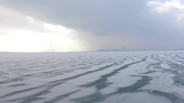 Flying over iced sea or lake by helicopter .