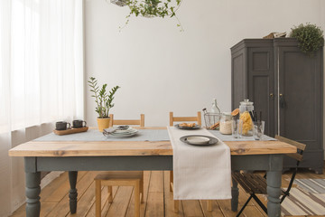 dining wooden table and chairs in modern home with elegant table setting