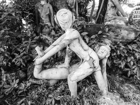Old stone statue depicting a Nuad Boran (Thai massage) move at famous Wat Pho (Buddhist Temple) in Bangkok, Thailand