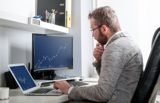 Investor analyzing stock market with charts on screen at home office