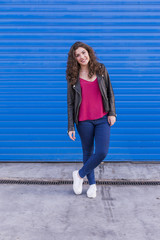 outdoors portrait of a beautiful Young woman over blue background. Casual clothing. lifestyle