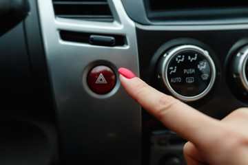 Obraz na płótnie Canvas turning on car air conditioning system,finger hitting car emergency light botton,Hand tuning fm radio button in car panel.