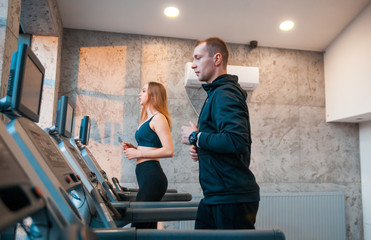 Fototapeta na wymiar People running on machine treadmill at fitness gym
