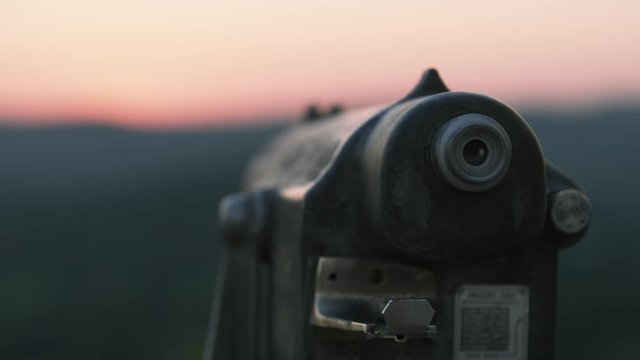 A Monocular Looks Out Over A Valley At Sunrise