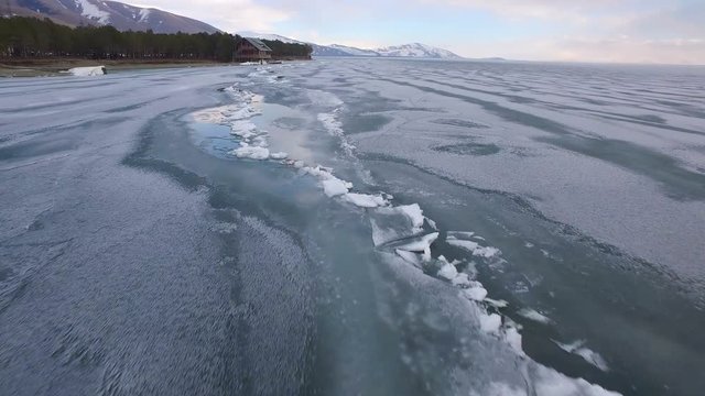 Flying over iced sea or lake by helicopter .