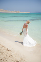 Fototapeta na wymiar Beautiful bride on a tropical beach wedding day