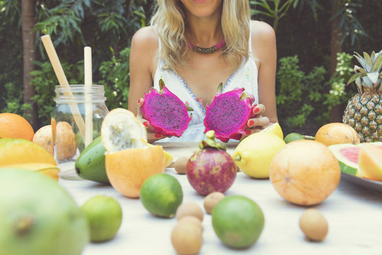 Beautiful woman holding dragon fruits. Tropical fruits concept.