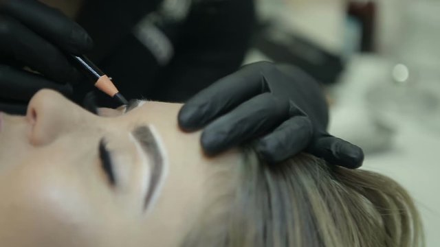 Close up of cosmetologist making microblading procedure.
