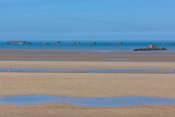 Fototapeta na wymiar Arromanches-les-Bains beach with the remains of the Mulberry harbour in Normandy, France