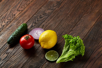 Fresh vegetables still life. Veges lined up on a wooden background, top view, close-up, selective focus, copy space.