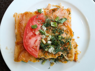 Traditional Italian lasagna with tomato, dill and green onions