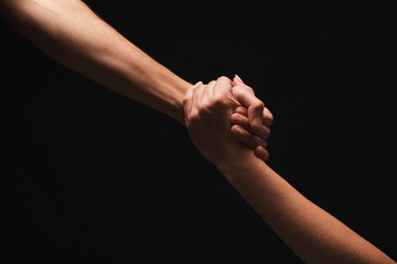 Hands of man and woman in love, isolated on black